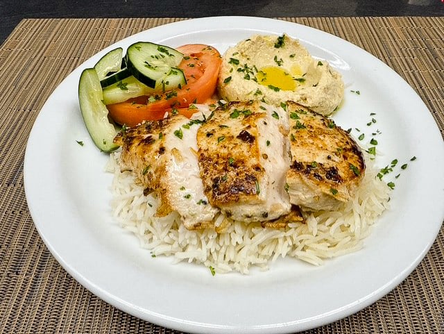 Mediterranean chicken with basmati rice, hummus, cucumbers, and tomatoes served at Leisure Vale Assisted Living in Glendale, CA