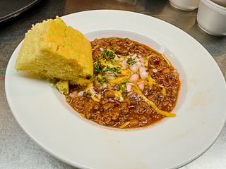 Homestyle beef and bean chili with onions and parsley, served with warm cornbread at Leisure Vale Assisted Living
